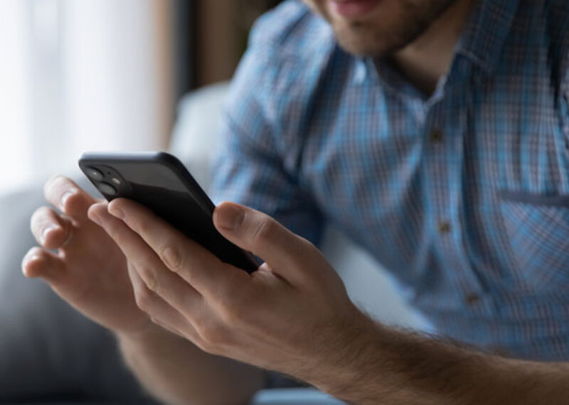 man's hands holding a black iphone